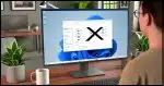 A photorealistic image showing a computer screen with Windows File Explorer open. The default folders like Desktop, Documents, Downloads, Pictures, Music, and Videos are visible, but crossed out with an 'X'. The scene includes a relaxed office setting with a cup of coffee and a plant on the desk, and a person sitting at the desk, contentedly working on the computer.